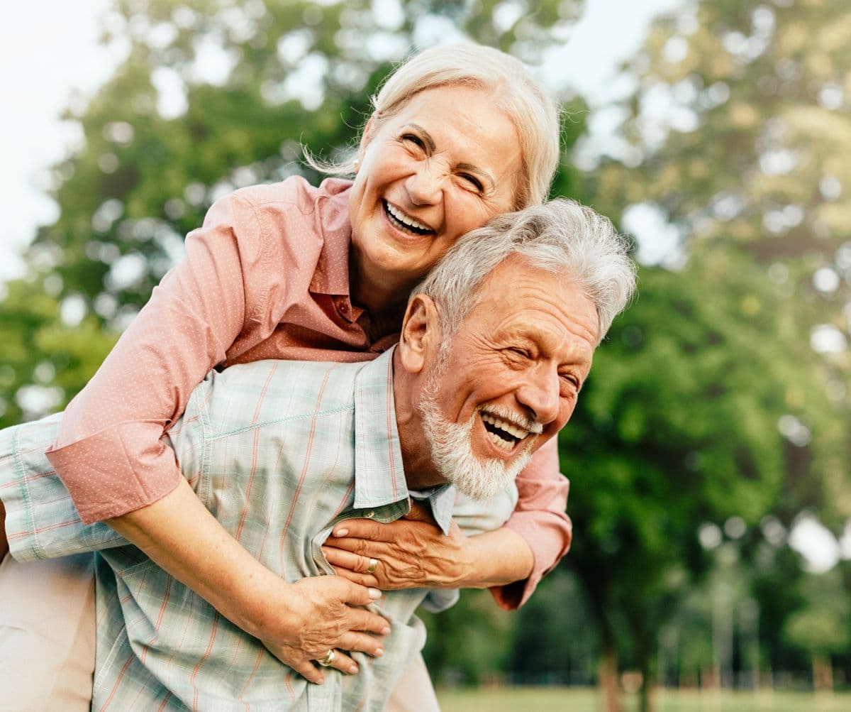 Patient comparing fixed implant-supported teeth with removable dentures during a dental consultation
